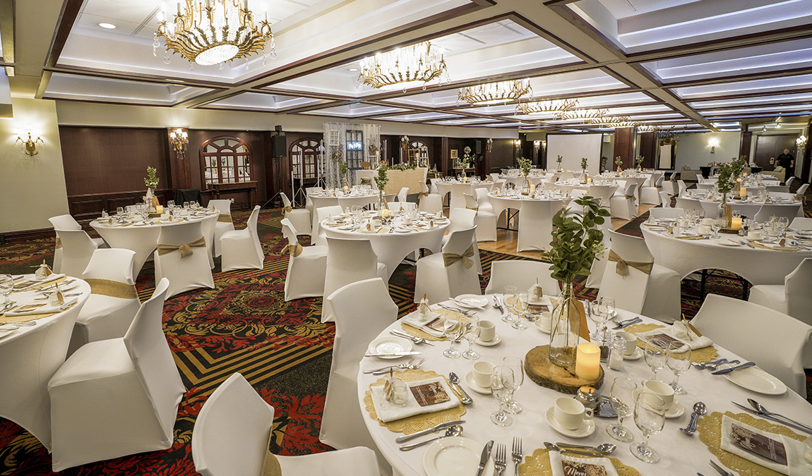 Reception room decorated with white tables and chairs, ideal for events at the Royal Palace of Jaro Hotels.