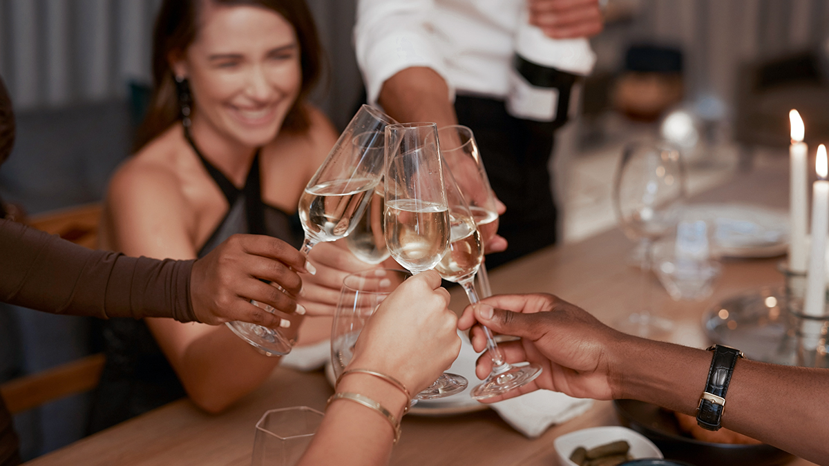 Guests cheerfully toast with glasses of champagne, celebrating unforgettable moments in the elegant reception room of JARO Hotels' Quebec Hotel.
