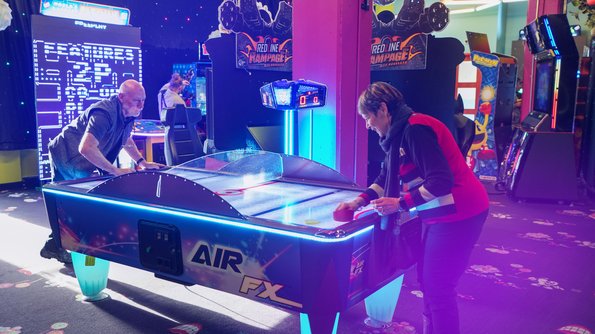 Carie Factory Adultes concentrés sur des jeux d’arcade palpitants au Carie Factory, dans un décor immersif et divertissant.