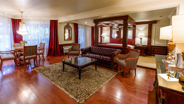 Suite Empire spacieuse avec décor classique, très grand lit, bain à remous double, grande douche et balcon avec table, 4 chaises et vue sur le jardin de l’Hôtel Québec Inn.