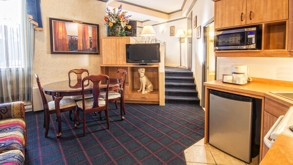 Chambre Grande Écono-Cuisinette avec un grand lit et divan-lit, offrant un espace pratique et confortable avec une cuisinette à l'Hôtel Auberge
