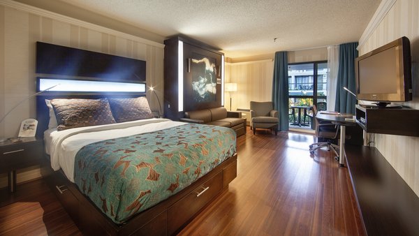 Chambre d'hôtel contemporaine avec deux grands lits, bureau, télévision et balcon avec vue sur le jardin au Québec Inn