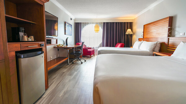 Chambre Classique Plus avec deux lits doubles et un bain, offrant confort et détente à l'Hôtel Lindbergh