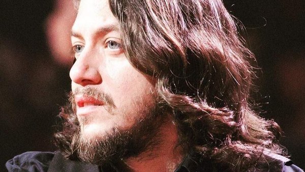 Bashir Dahrieh lors d'une prestation musicale dans un jardin tropical à l'Hôtel Plaza,  avec une ambiance décontractée.