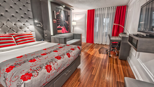 Chambre contemporaine avec deux grands lits, dont un escamotable se transformant facilement en canapé, et une terrasse offrant une vue sur le jardin de l'Hôtel Plaza.