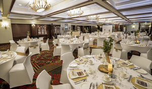 Élégante salle de bal au Palace Royal, avec des tables couvertes de nappes blanches et des chaises, pour des réceptions mémorables