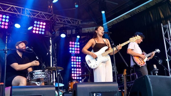 MEV trio pour une performance musicale intime et captivante dans le jardin tropical de L'Hôtel Québec, avec un décor chaleureux et des lumières douces en arrière-plan.