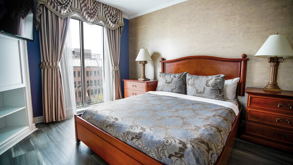 Suite adaptée du Palace Royal, comprenant un grand lit, un divan-lit et une télévision, avec vue sur la ville.