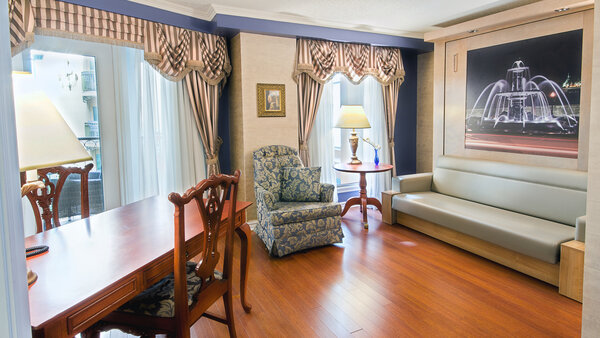 Elegant two-room suite with sofa, table and chairs, offering a soothing view of the Royal Palace garden