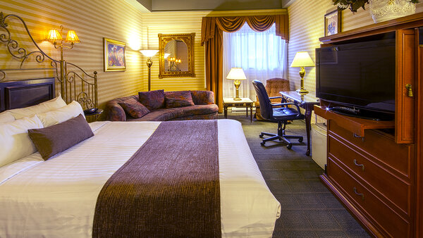 Chambre Écono-Confort avec un grand lit et bain thérapeutique simple, offrant confort à l'Hôtel Auberge.