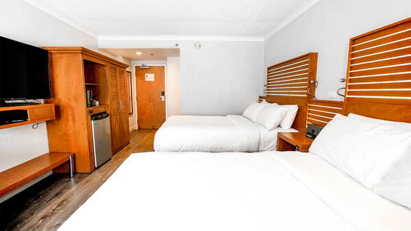 Chambre classique avec deux lits doubles, télévision moderne et tout le confort nécessaire pour un séjour agréable à l'Hôtel Lindbergh