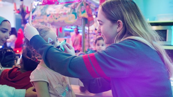Carie Factory Une activité de maquillage de Pâques au Carie Factory, où un enfant reçoit une peinture faciale ludique réalisée par un membre de l’équipe.