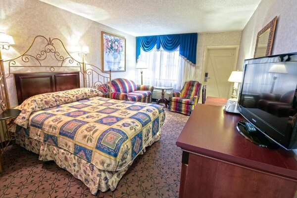 Chambre Grande Écono avec un grand lit et un divan-lit, offrant confort et praticité à l'Hôtel Auberge