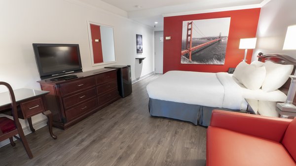 Traditional room at Hôtel Québec Inn with king-size bed, sofa bed and private terrace offering a soothing garden view