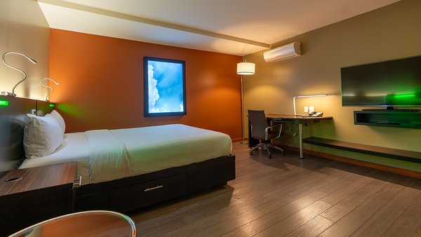 Chambre tendance avec un grand lit, sans fenêtre, offrant un espace intime et confortable à l'Hôtel Must.