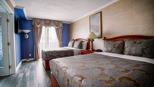 Family suite at the Palace Royal, with two beds and a TV, offering comfort and space
