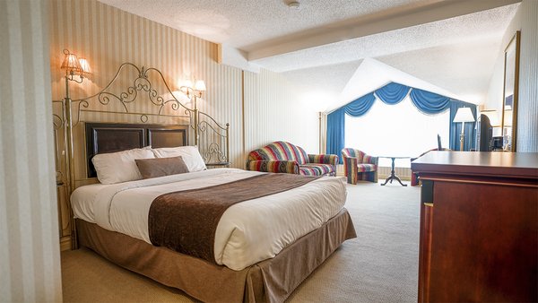Chambre Grande Écono avec un grand lit et un divan-lit, offrant confort et praticité à l'Hôtel Auberge