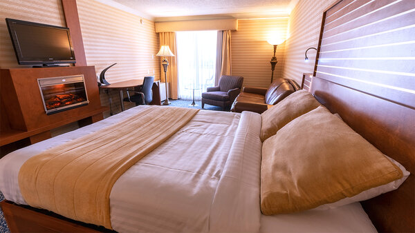First Class room with king-size bed, double whirlpool bath and cozy fireplace, offering luxury and relaxation at the Hotel Lindbergh.