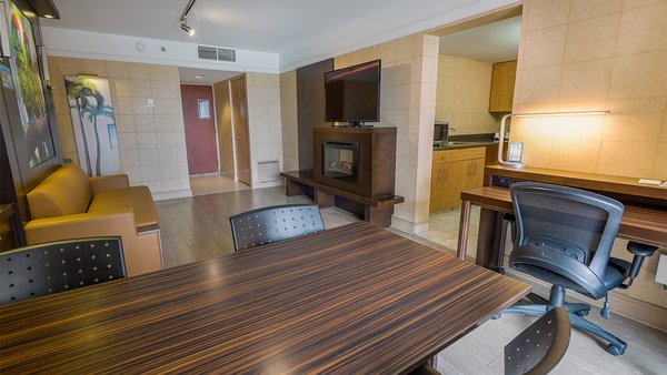 Comfort room at Hôtel Québec, with two queen-size beds, dining table, chairs, fireplace and kitchenette, offering a spacious, comfortable and welcoming space for an unforgettable stay.