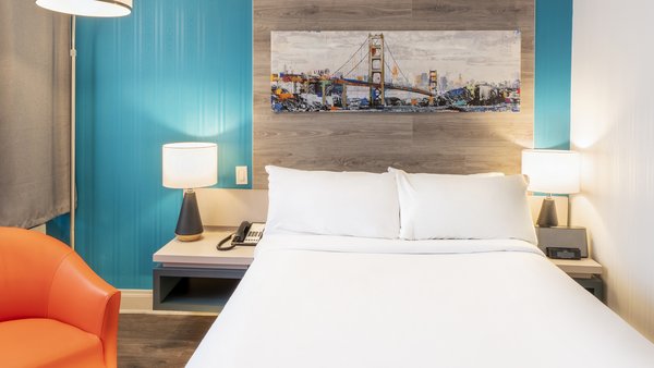 Chambre d'hôtel traditionnelle avec un lit double, une chaise confortable et une ambiance chaleureuse au Québec Inn