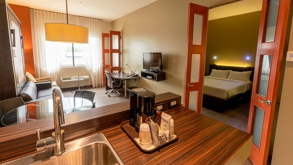 Grande Suite spacieuse avec trois grands lits, 3 pièces séparées et une cuisinette entièrement équipée, offrant confort et praticité à l'Hôtel Must