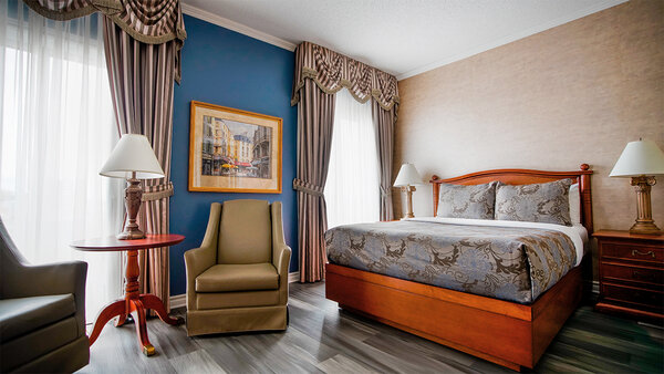 Hotel room at the Palace Royal, with king-size bed, chair and table, overlooking Quebec City.
