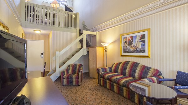 Chambre Mezzanine avec un grand lit et divan-lit double, offrant un espace confortable et intime à l'Hôtel Auberge