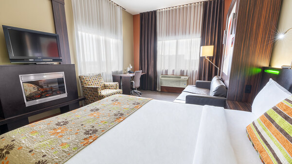 Trendy hotel room with two king-size beds, TV and cozy fireplace at Hotel Must