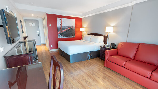 Chambre composée d’un grand lit et d’un divan-lit. La salle de bain est dotée d’un bain-douche à l’Hôtel Québec Inn