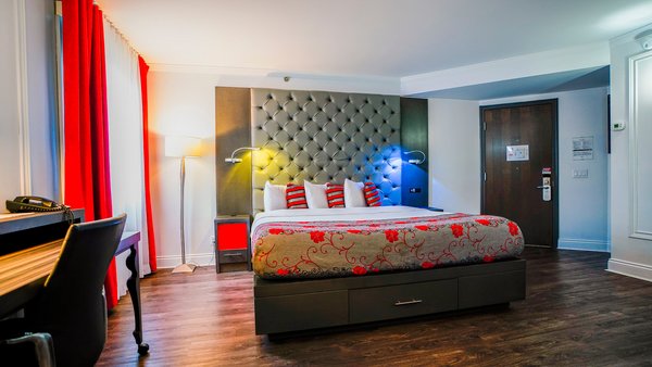 Elegant, accessible room with king-size bed, hushed atmosphere thanks to fireplace and window treatments, ensuring comfort and privacy.