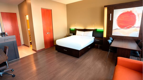 Studio Loft avec deux grands lits, un divan-lit et une table à manger, offrant un espace moderne et confortable à l'Hôtel Must