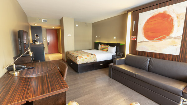 Trendy hotel room with two large beds, one of which can easily be converted into a sofa, creating a welcoming atmosphere at Hotel Must