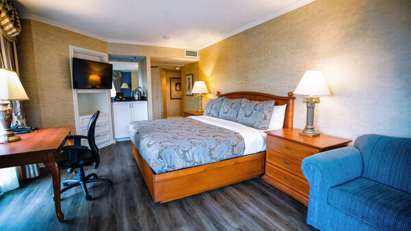Elegant room at the Palace Royal, with king-size bed, desk and TV, and panoramic view of the city.