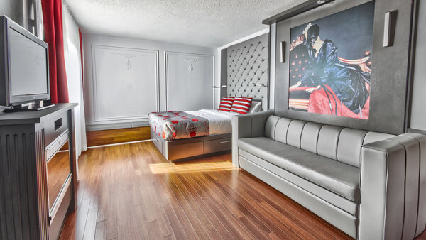 Contemporary, adapted bedroom with two large beds, one of which folds out into a sofa, offering comfort and accessibility. Television, fireplace and window treatments guarantee a cosy atmosphere.