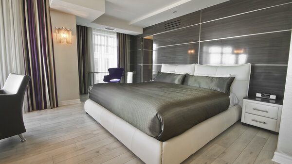 Spacious room with king-size bed, desk and TV, offering panoramic city views