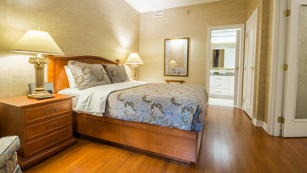 Spacious two-room room at the Palace Royal, with double bed, chest of drawers and bedside table, offering a partial view of the garden.