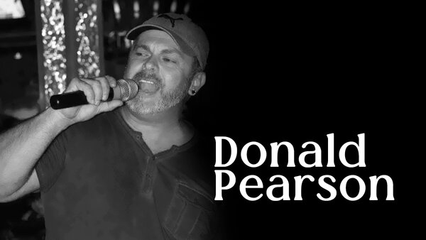 Donald Pearson lors d'une prestation musicale à l'Hôtel Palace, chantant sur scène avec un micro