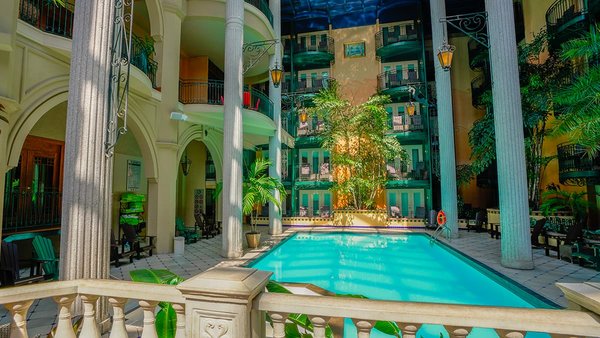 Bright indoor courtyard at Jardin Hôtel Plaza in Quebec with heated pool, palm trees and a relaxing tropical atmosphere