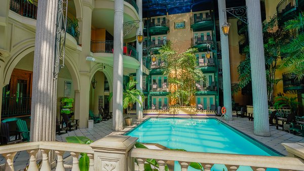 Bright indoor courtyard at Jardin Hôtel Plaza in Quebec with heated pool, palm trees and a relaxing tropical atmosphere