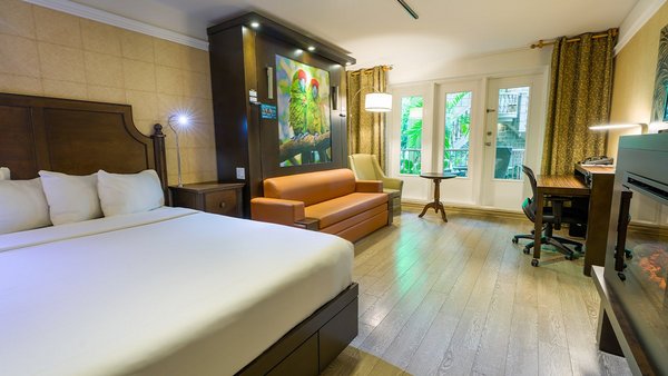 Chambre Confort à l'Hôtel Québec, équipée de deux grands lits, d'un foyer chaleureux et d'une terrasse offrant une vue paisible sur le jardin.