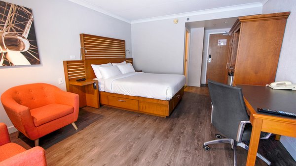 Chambre classique à l'Hôtel Lindbergh avec un grand lit, un bureau et une chaise, offrant un espace confortable et élégant à l'Hôtel Lindbergh