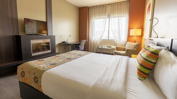 Trendy Intimacy Room at the Quebec Inn, with a king-size bed, comfortable sofa bed, modern TV and elegant decor for a chic and pleasant stay at Hotel Must