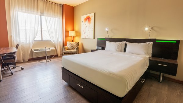 Trendy Intimacy Room at the Quebec Inn, with a king-size bed, comfortable sofa bed, modern TV and elegant decor for a chic and pleasant stay at Hotel Must