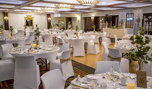 Elegant ballroom at the Royal Palace, with white tablecloth tables and chairs for memorable receptions