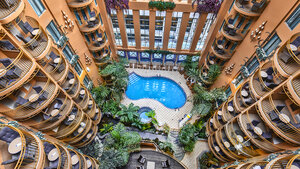 The view of the pool, the tropical garden, and the balconies of the rooms at Palace Royal.