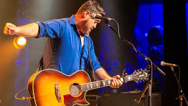 Le chanteur Nick Cloutier en pleine performance au Hotel Plaza, guitare à la main, captivant le public avec son énergie