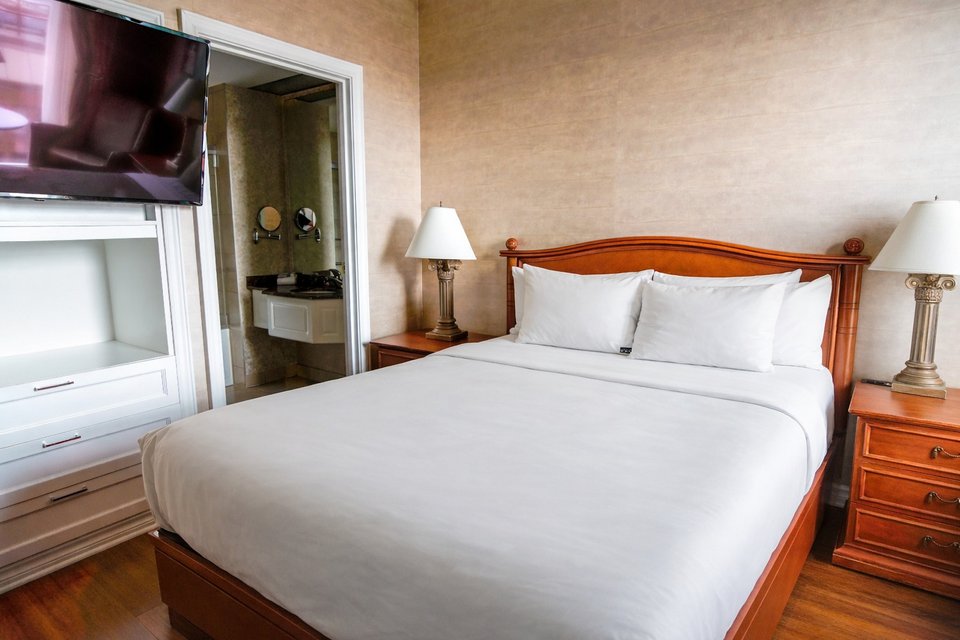 Chambre raffinée avec un lit, une commode et une télévision, vue panoramique sur Québec