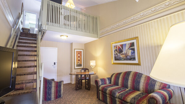 Mezzanine room with king-size bed and double sofa bed, offering a comfortable, intimate space at the Hôtel Auberge.