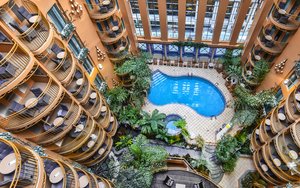 Vue sur la piscine, le jardin tropical et les balcons des chambres de Palace Royal
