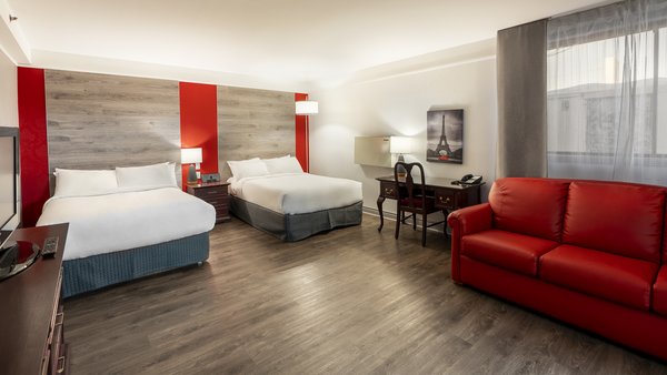 Chambre traditionnelle avec deux lits doubles, un divan-lit et un bain à remous au Québec Inn
